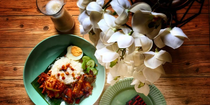 Platos de comida malaya en una mesa de madera.