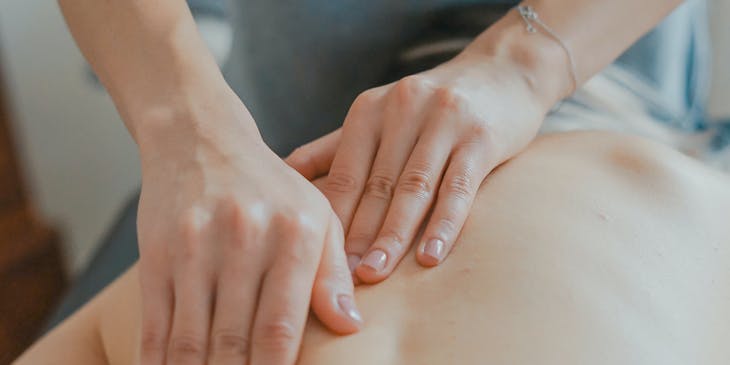 Massage therapist strategically massaging a client.