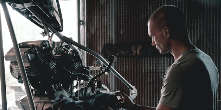 Un mecánico que trabaja en una motocicleta en un taller mecánico.