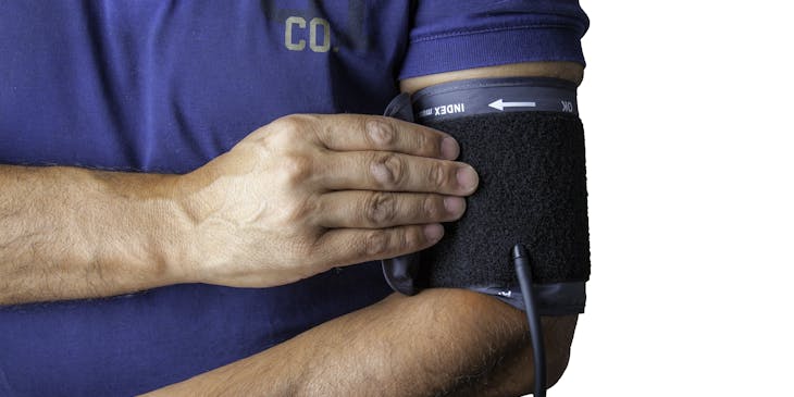 Man wearing a blood pressure cuff acquired from a medical supply store.