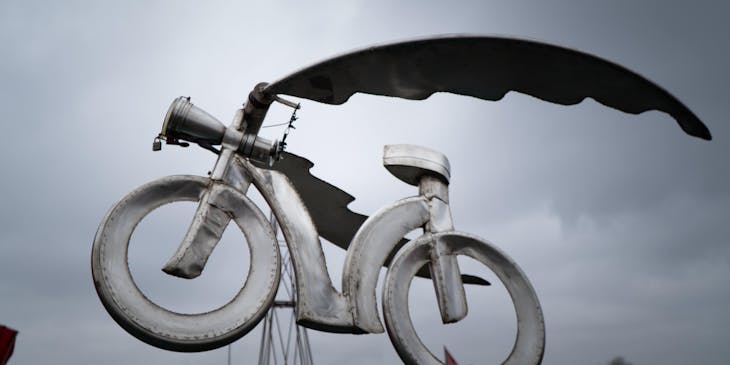 Una bicicleta de metal hecha por un negocio de arte en metal que se exhibe en un área exterior.