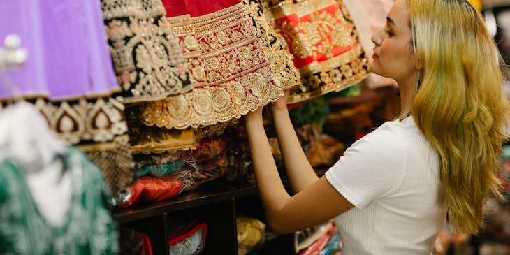 Une femme regarde les robes exposées dans une boutique mexicaine.