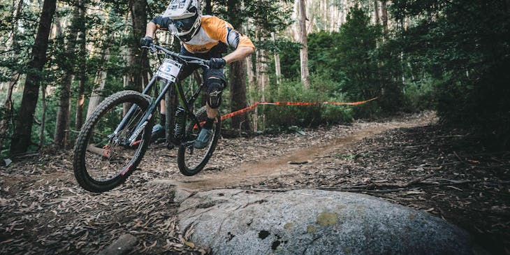 Un hombre en bicicleta en el bosque en un negocio de ciclismo de montaña.