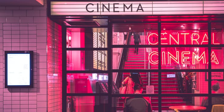 Um cinema iluminado em rosa e vermelho.