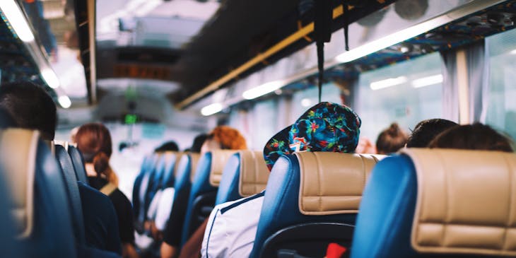 Personas viajando en un autobús en una empresa de transporte de pasajeros.