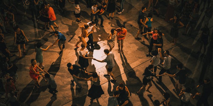 Grupo de gente reunida bailando salsa en una escuela de salsa.