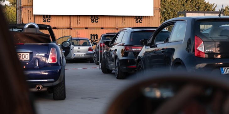 Autos esperando a que inicie una película en un autocinema.