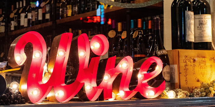 La vitrina de una botillería con botellas de vino y licor y un letrero que dice wine