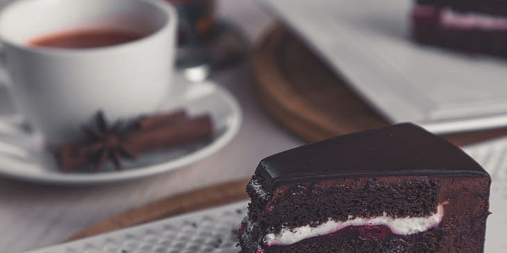 Una rebanada de pastel de chocolate y una taza de té en un café para merendar