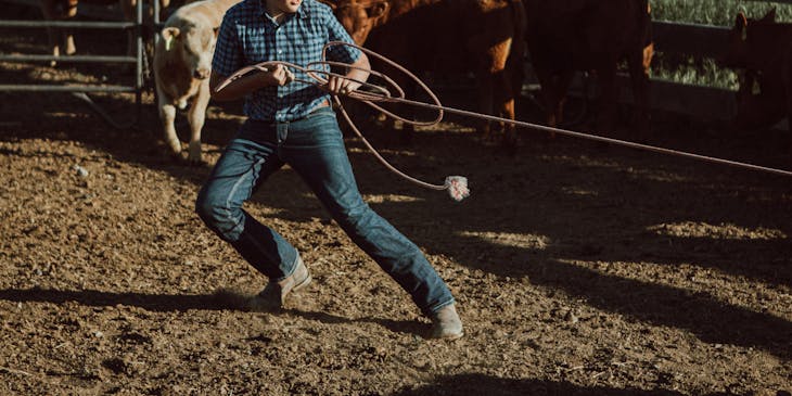 Un vaquero sosteniendo una soga en un club de rodeo.