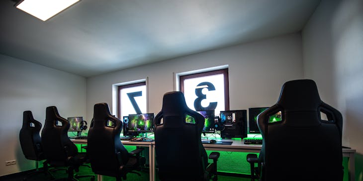 Interior de un club de juegos con sillas para gamer y computadoras.