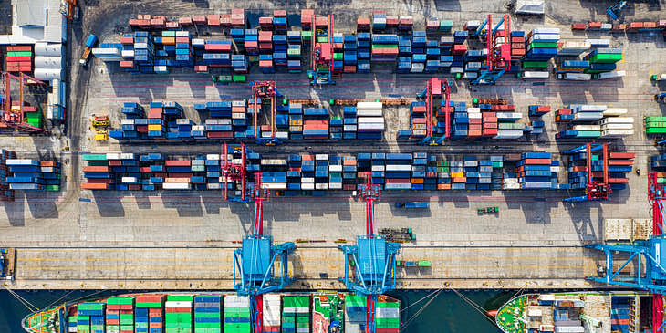 Barcos y contenedores en un puerto de una empresa de distribución.