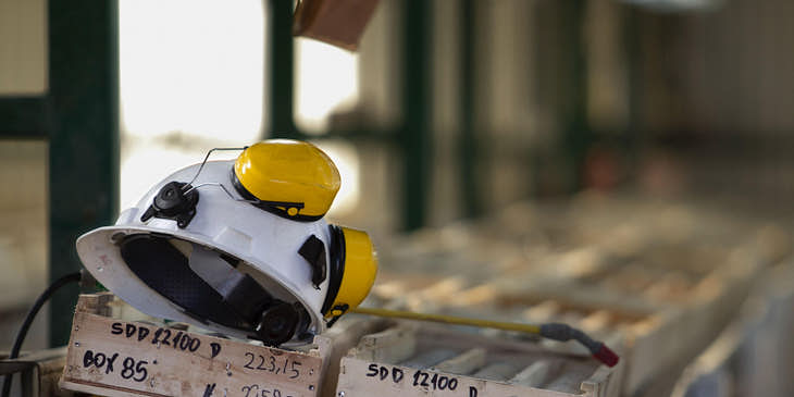 Un casco de minero sobre una tabla de madera en una mina de una empresa de extracción de oro.