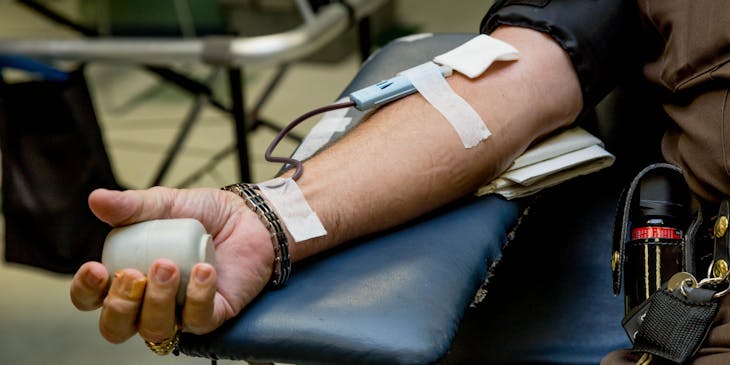 Brazo de un hombre canalizado para donar sangre en una empresa de hemoterapia.