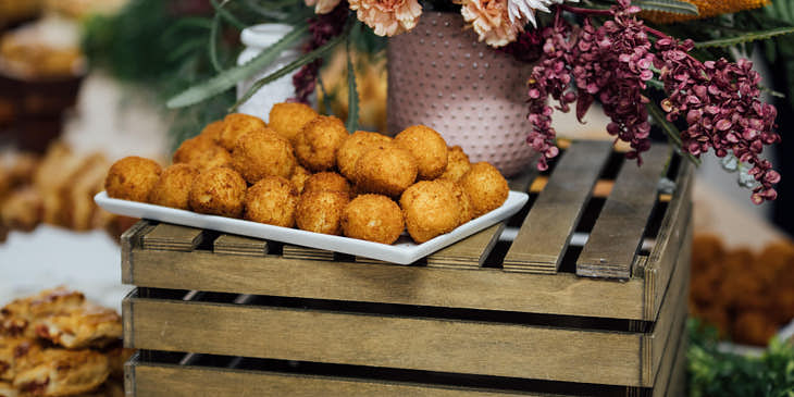 Un montón de buñuelos de bacalao sobre una bandeja de metal en un negocio de buñuelos de bacalao