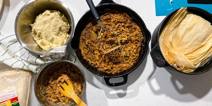 Hojas de humita, guisos y masa de maíz en ollas en un negocio de humitas listo para ser preparado.