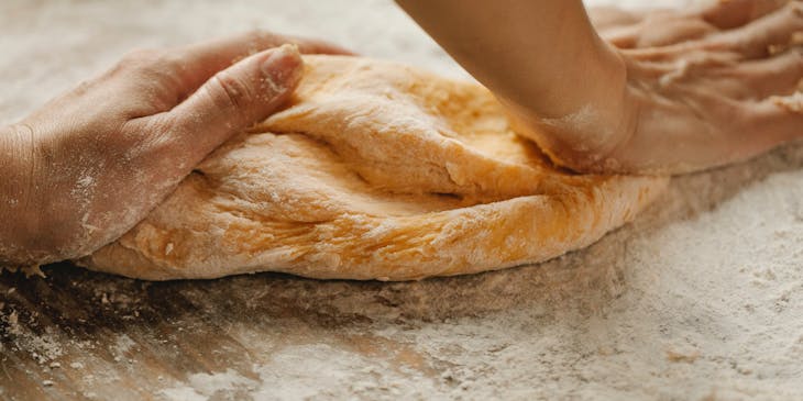 Unas manos amasando un pan en un negocio de pan cubano.