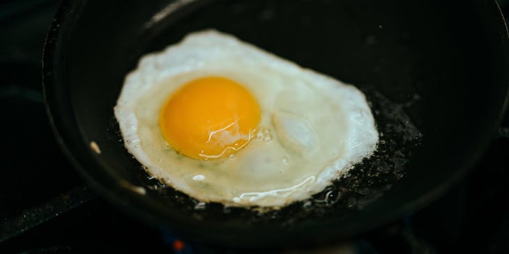 Un huevo frito sobre fondo negro en un negocio de revuelto de gramajo