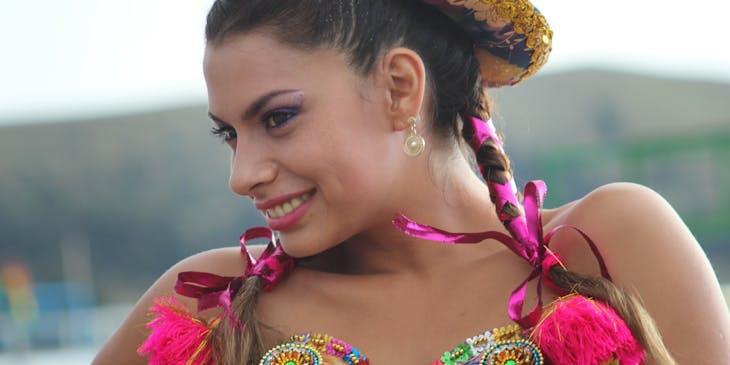 Una mujer vistiendo un sombrero de chola en una celebración boliviana.