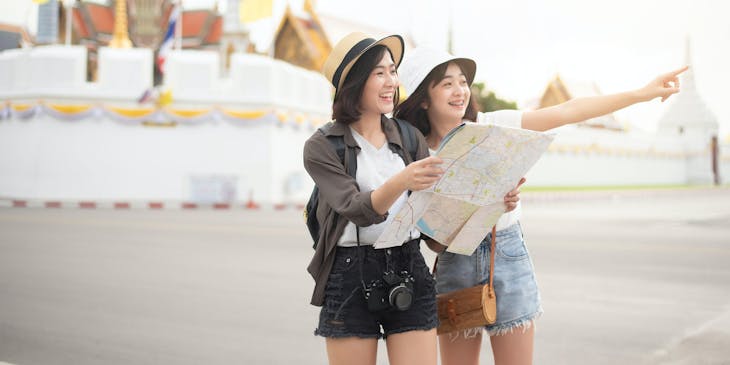 Dos mujeres sosteniendo un mapa en un negocio de turismo.