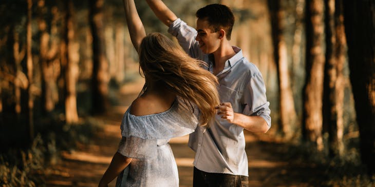 Una pareja bailando en medio del bosque en un negocio en pareja.