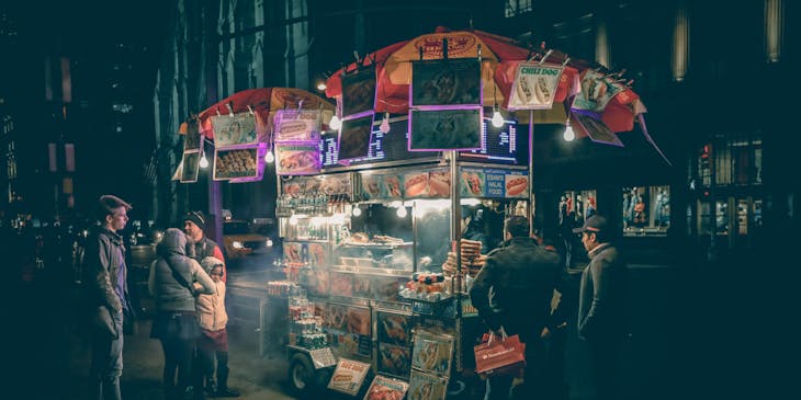 Un puesto de jochos sirviéndole jochos a sus clientes en una esquina.