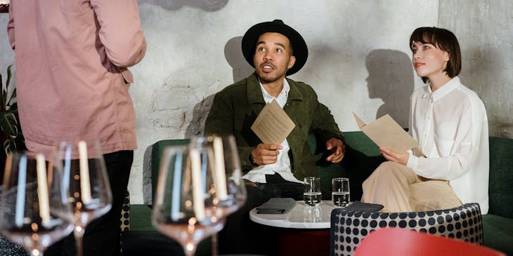 Una pareja ordenando sus platillos al mesero de un restaurante boliviano.