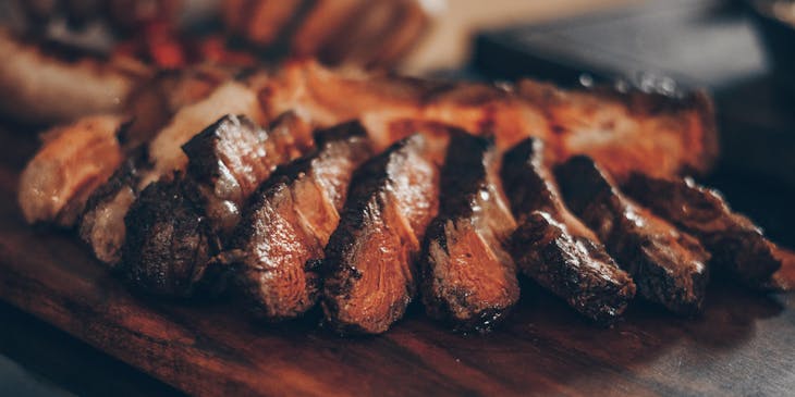 Un corte de carne con corteza e interior jugoso y rosado en un restaurante de churrascos.