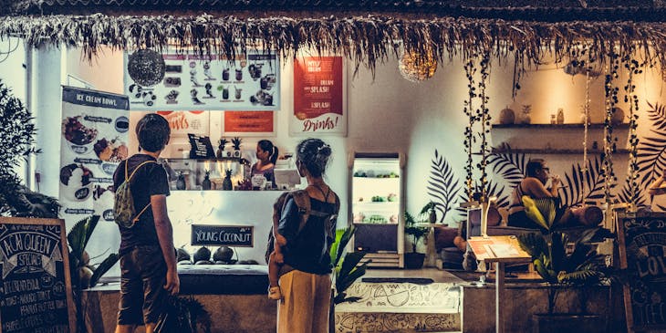 Un par de personas admirando el menú de un restaurante de comida centroamericana.