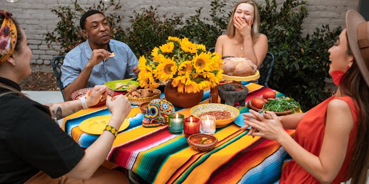 Un grupo de amigos sentados a la mesa, comiendo y riendo en un restaurante de comida corrida.