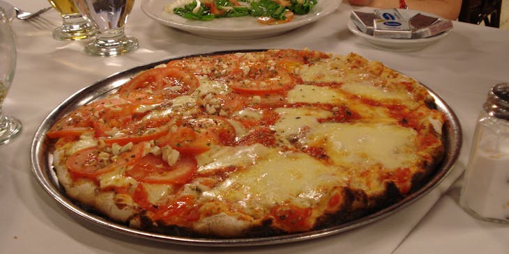 una pizza argentina recién salida del horno en medio de una mesa en un restaurante de pizza argentina