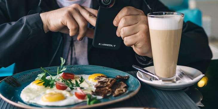 Un comensal tomando una foto con su celular a su platillo en un restaurante ecuatoriano