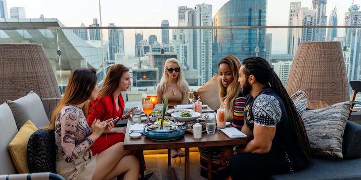 Un grupo de amigos comiendo en una terraza de un restaurante neozelandés.