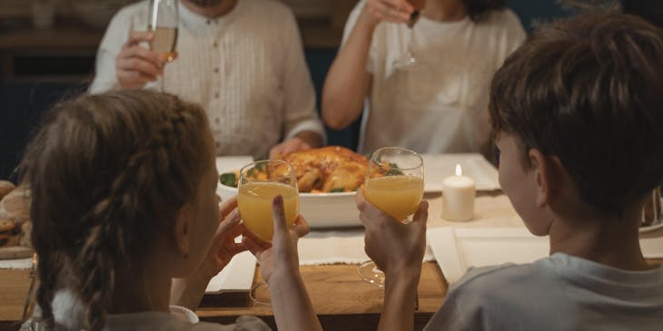 Una familia brindando y comiendo en un restaurante rumano.