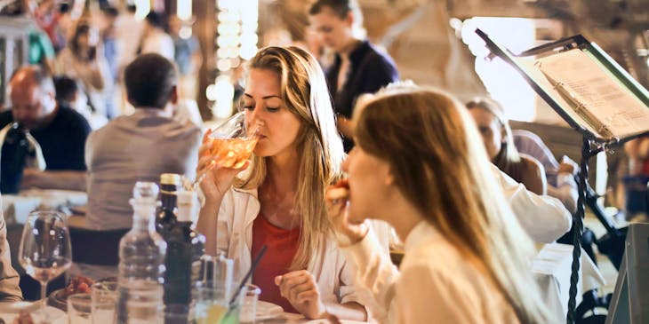 Un par de mujeres comiendo y bebiendo en un restaurante sueco.