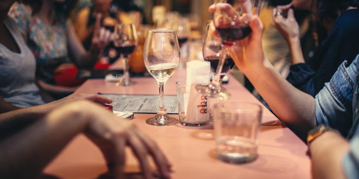 Mujeres al interior de un restaurante valenciano tomando vino en copas.