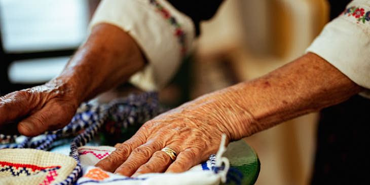 Manos de anciana Kuna sobre unas molas en un taller de confección de molas.