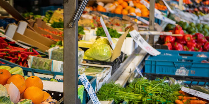 Diferentes cajas con frutas y verduras puestas a la venta en una tienda agrícola.