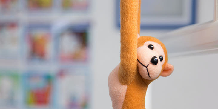 Changuito de felpa colgando en una tienda de bebé.