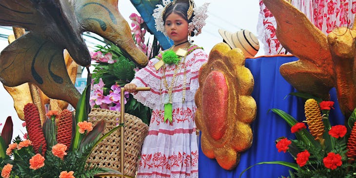 Una niña en un carro alegórico en un desfile de Panamá vistiendo un traje típico adquirido en una tienda de polleras.