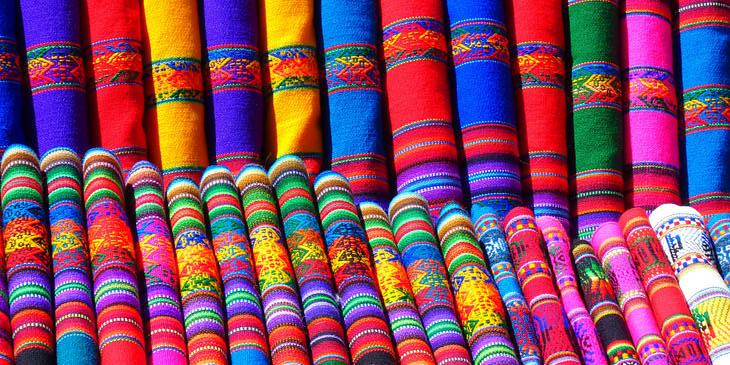 Telas de colores acomodadas y dobladas en una tienda de textiles típicos de Guatemala