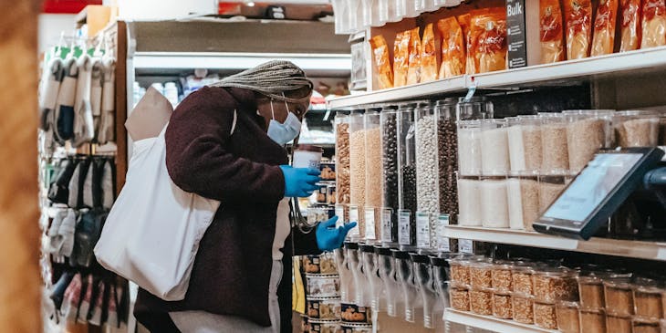 Una mujer eligiendo granos y cereales  en una tienda healthy.