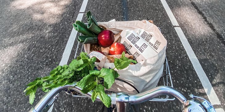 Una canasta de bicicleta llena de comida saludable por parte un negocio con nombre saludable.