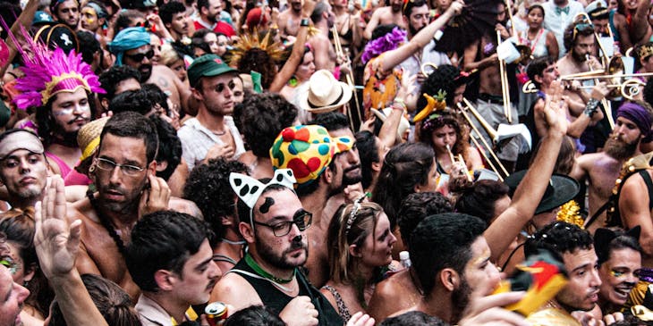 Diversas pessoas fantasiadas em um bloco de carnaval.