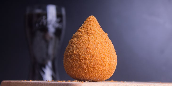 uma coxinha na mesa de uma loja de coxinhas