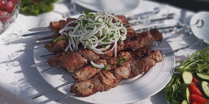 Del kebab servito su un piatto bianco in un ristorante iraniano.