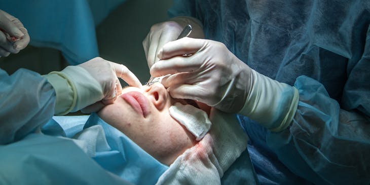 Plastic surgeon performing facial surgery.