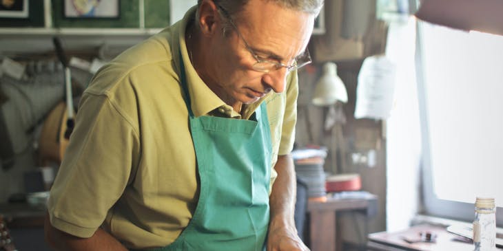 A man carefully repairing a violin.