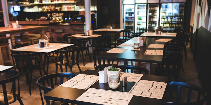 Un restaurant vide avec des sets de table sur les tables.