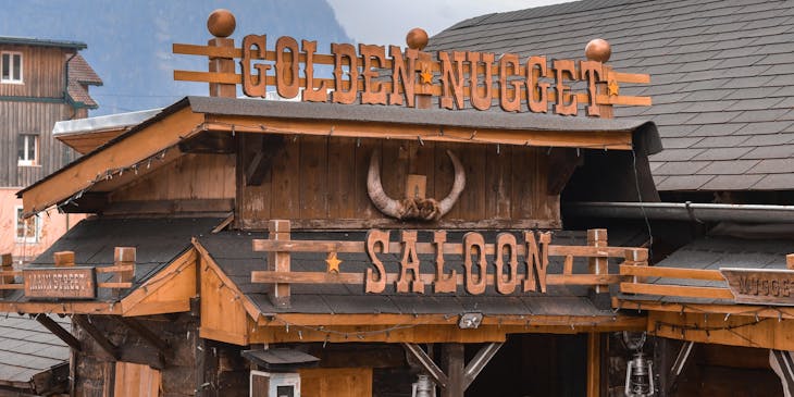 An old building facade with the words "Golden Nugget Saloon" mounted to the wall.